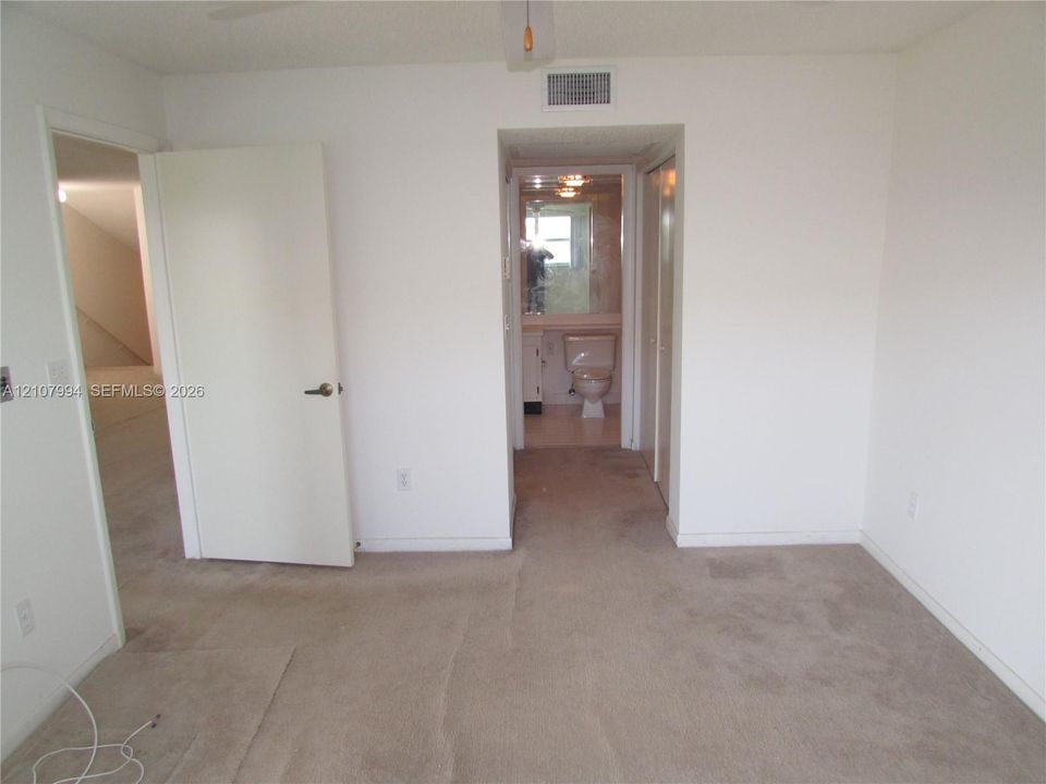 Neutral-toned carpeting, solid-core interior doors, and built-in closet storage