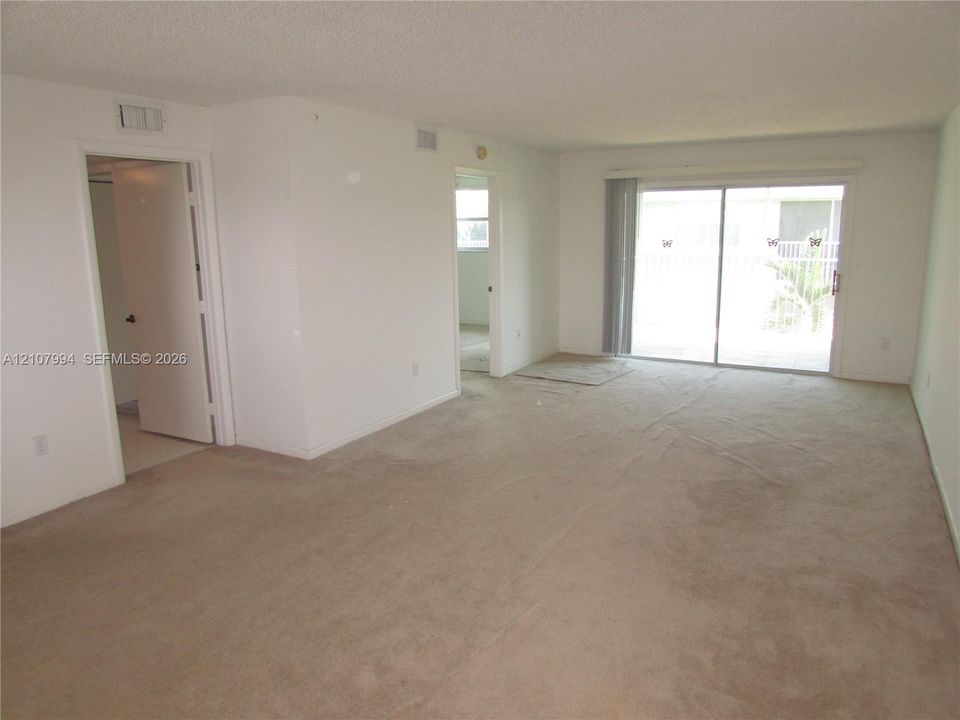 Living area featuring neutral carpeting and sliding glass doors with exterior access