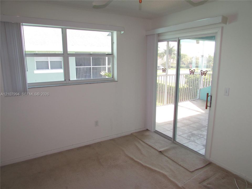 Interior space featuring a horizontal sliding window, full-length sliding glass door, and covered patio with tiled flooring