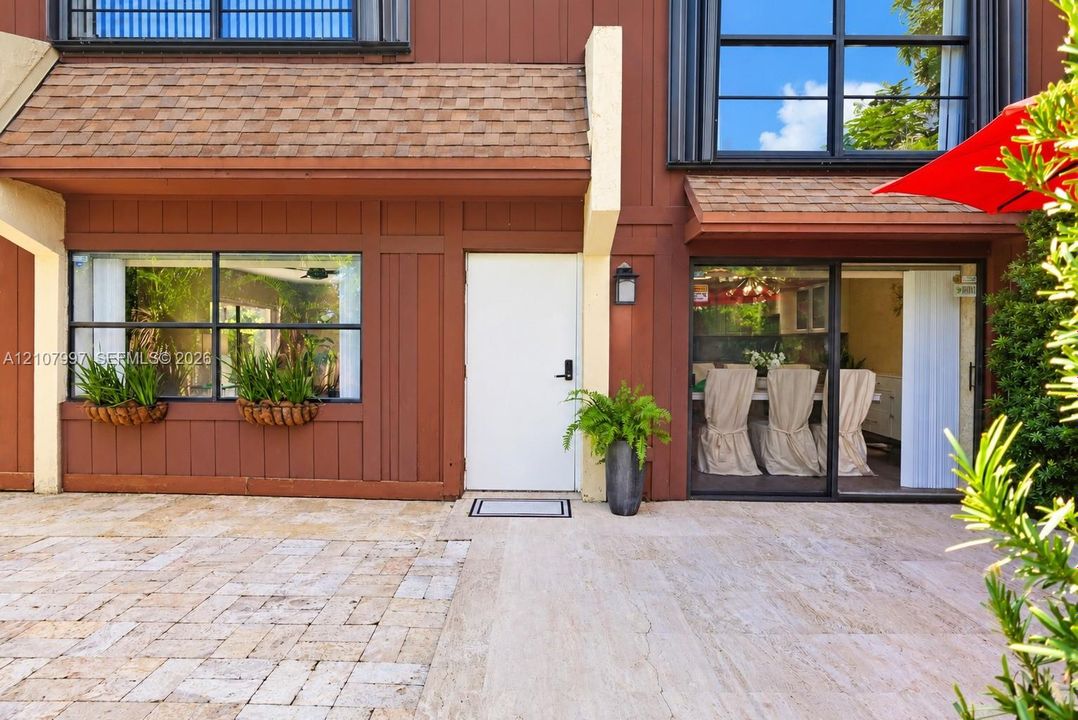 Professional pictures coming soon! Open-concept interior featuring textured stone accent walls, high-gloss black tile flooring, and a staircase with wood beam  & metal handrail