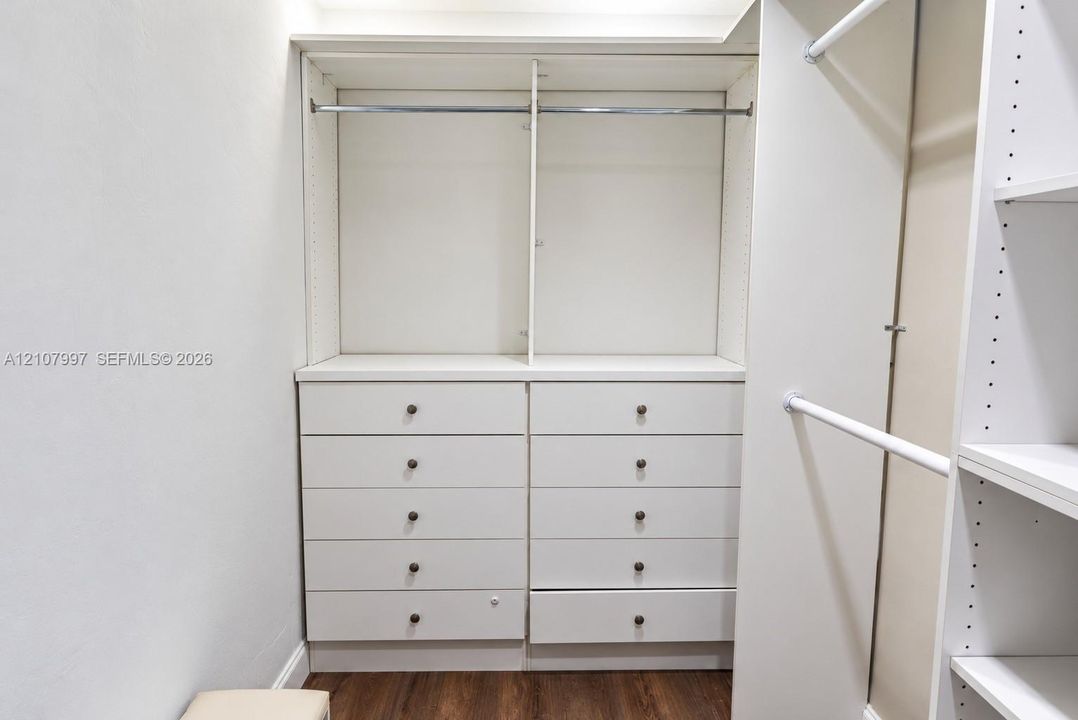 Walk-in closet featuring white built-in shelving
