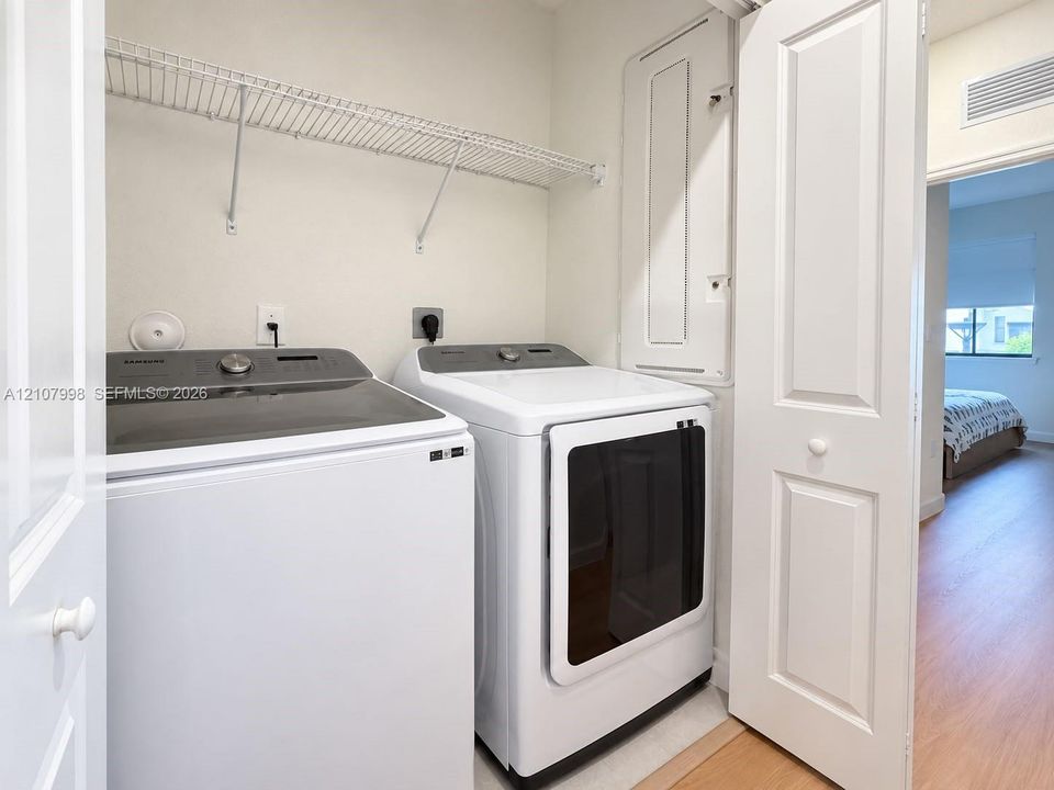 Laundry area featuring a dedicated closet with white bifold doors, wall-mounted wire shelving, and an integrated electrical panel