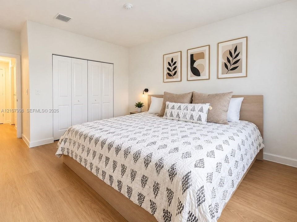 Neutral wall tones, wood-finish flooring, and built-in closet with multi-panel doors