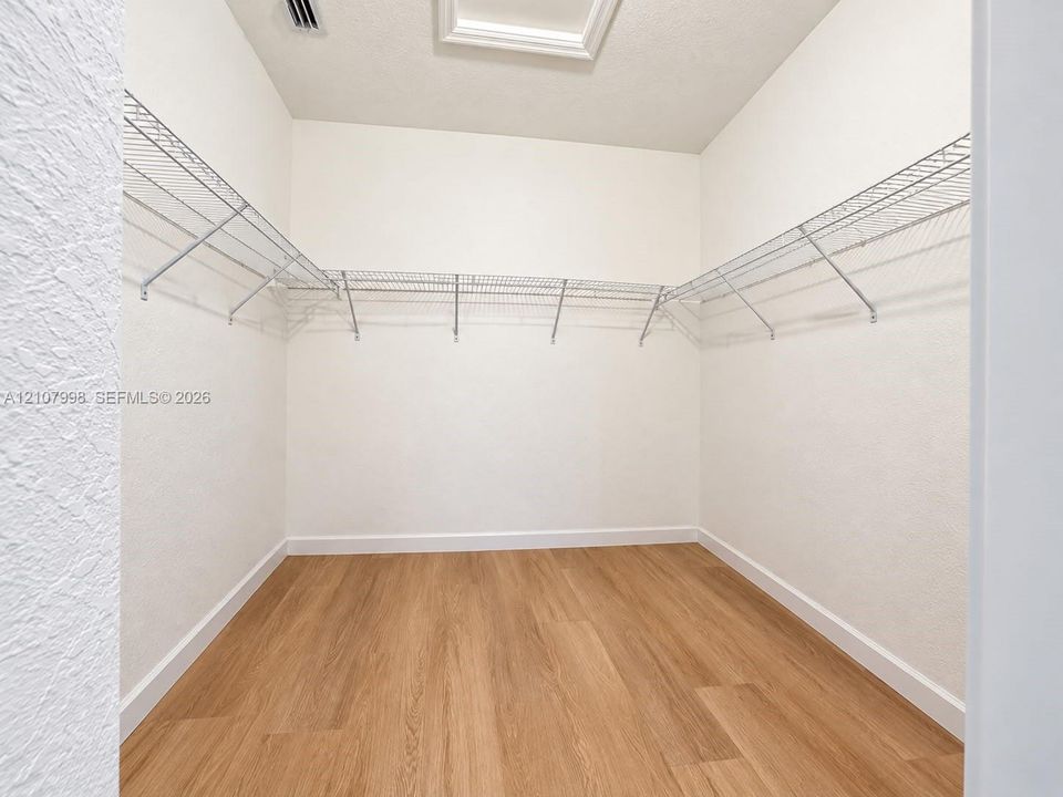 Storage space featuring wood-finish flooring and integrated wire shelving