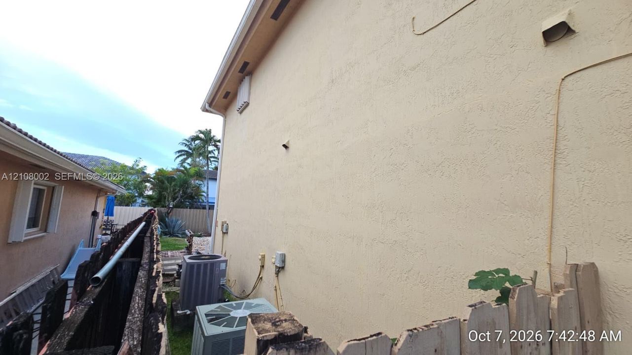 Stucco exterior wall with integrated utility access and mounted climate control units