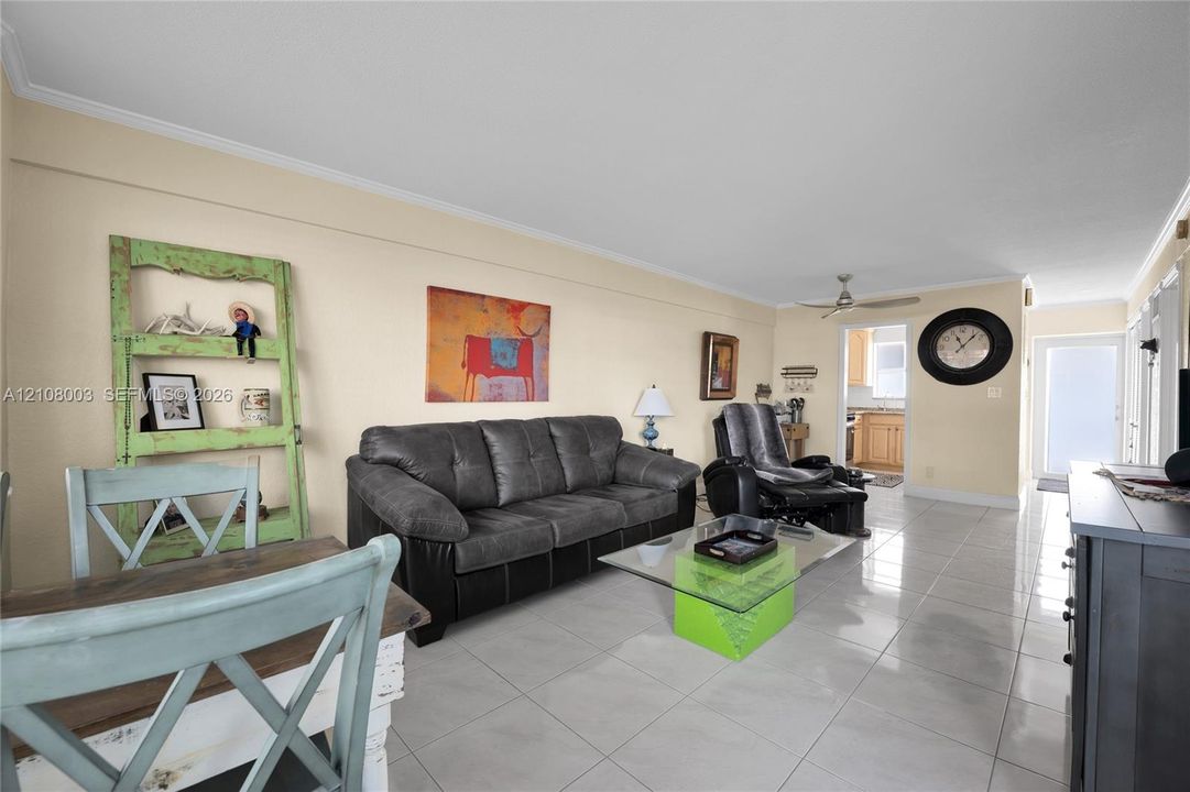 Large-format ceramic tile flooring, ceiling fan with light fixture, and recessed entry door