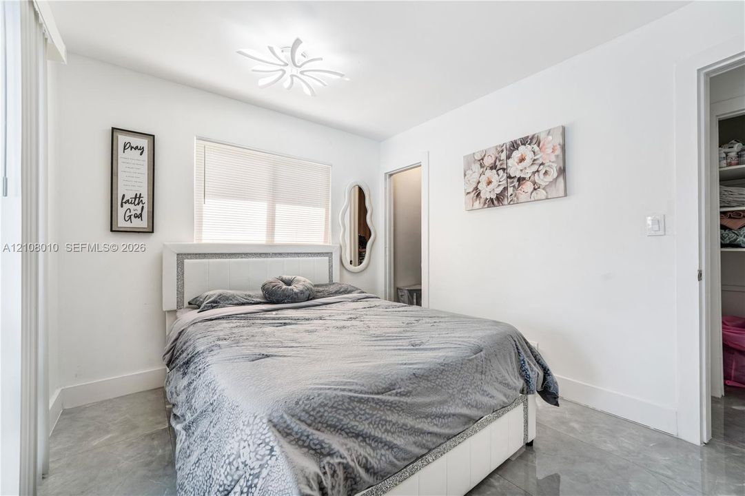 Neutral-toned stone-finish tile flooring, recessed ceiling lighting with a modern multi-point design, and a walk-in closet