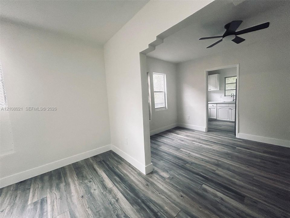 Interior space featuring wood-finish flooring, a stepped archway, and a ceiling fan