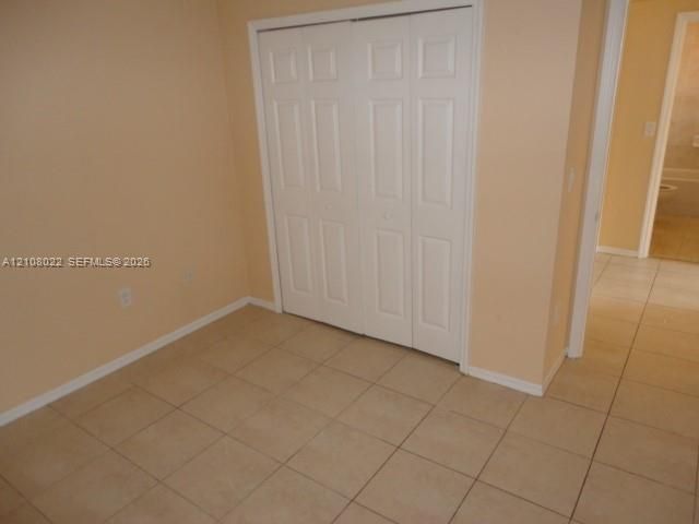 Room featuring tile flooring and a white paneled bi-fold closet