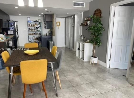 Open-concept interior featuring large-format ceramic tile flooring, recessed lighting, and multi-panel interior doors
