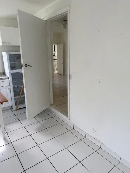White tile flooring, shaker-style cabinetry, and stone-finish countertops