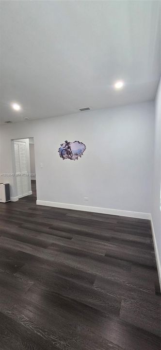 Interior space featuring dark wood-finish flooring, recessed ceiling lighting, and a bi-fold door