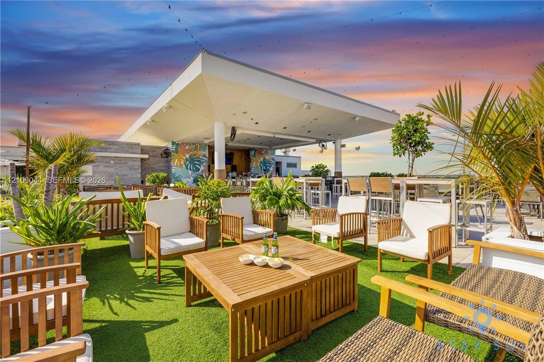 Rooftop terrace featuring a covered pavilion, built-in bar, tile flooring, and integrated overhead lighting