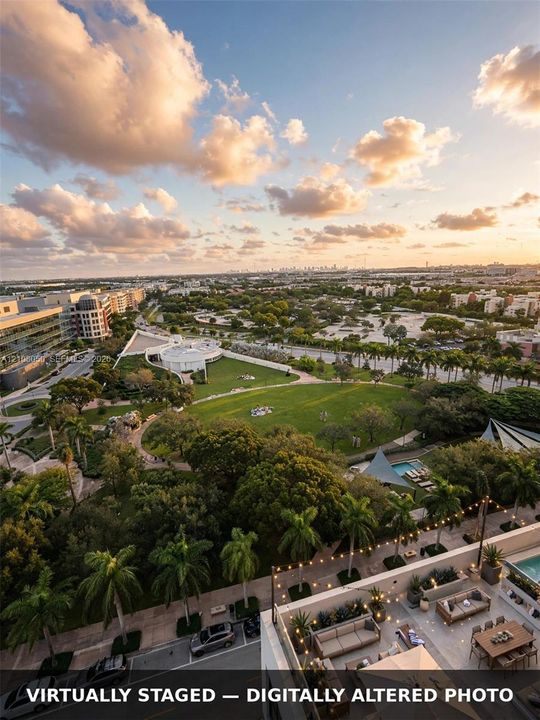 Rooftop terrace featuring concrete flooring and perimeter string lighting, overlooking an expansive green space and mature palm trees