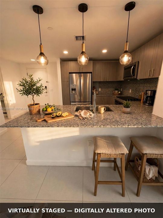 Kitchen featuring a stone-look countertop island, three glass pendant lights with wood-tone accents, stainless steel appliances, and flat-panel cabinetry