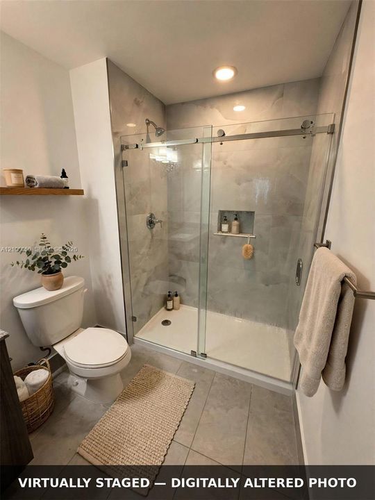 Walk-in shower featuring a frameless glass sliding door, integrated tiled wall niche, recessed lighting, and large-format tile flooring