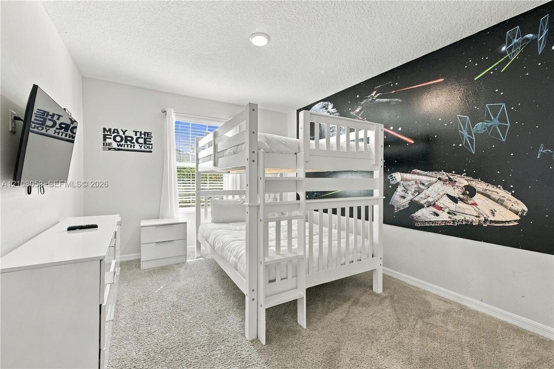 Neutral wall finishes, plush carpeting, recessed lighting, and a single-pane window with horizontal blinds