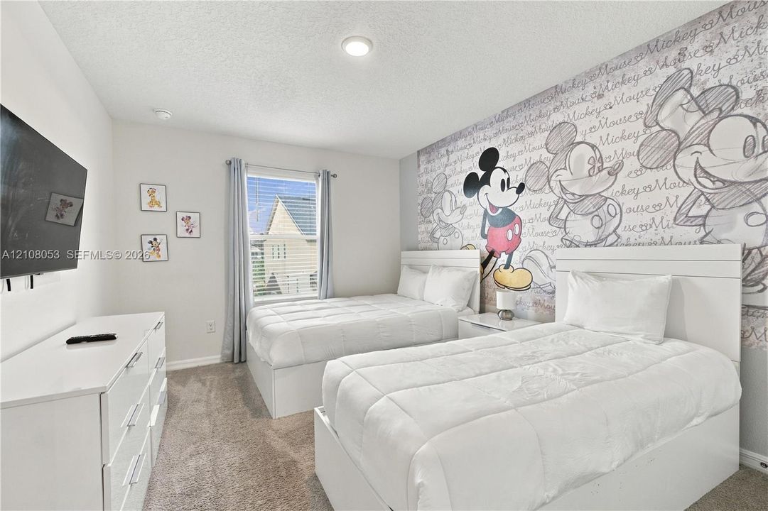 Bedroom featuring neutral-toned carpeting, a window with horizontal blinds, and a recessed ceiling lighting fixture