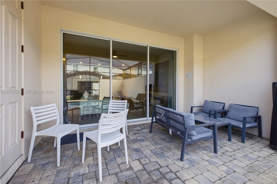 Covered patio featuring paver flooring and sliding glass doors