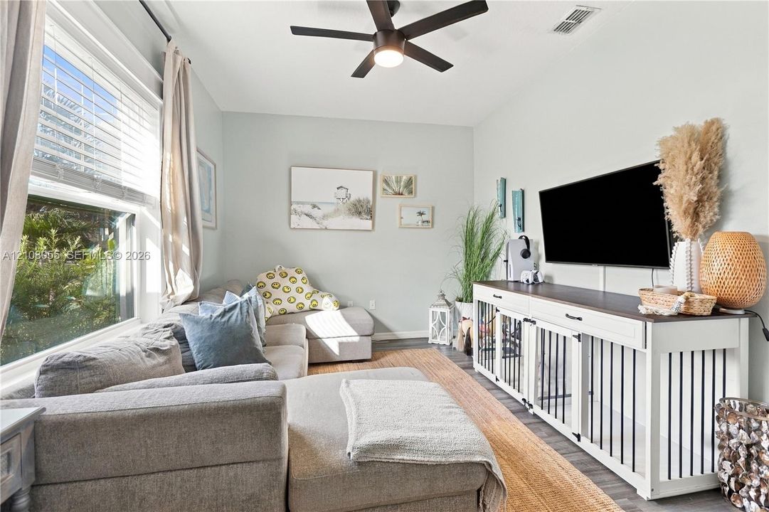 Room featuring a multi-pane window, ceiling fan with light fixture, and neutral wall color