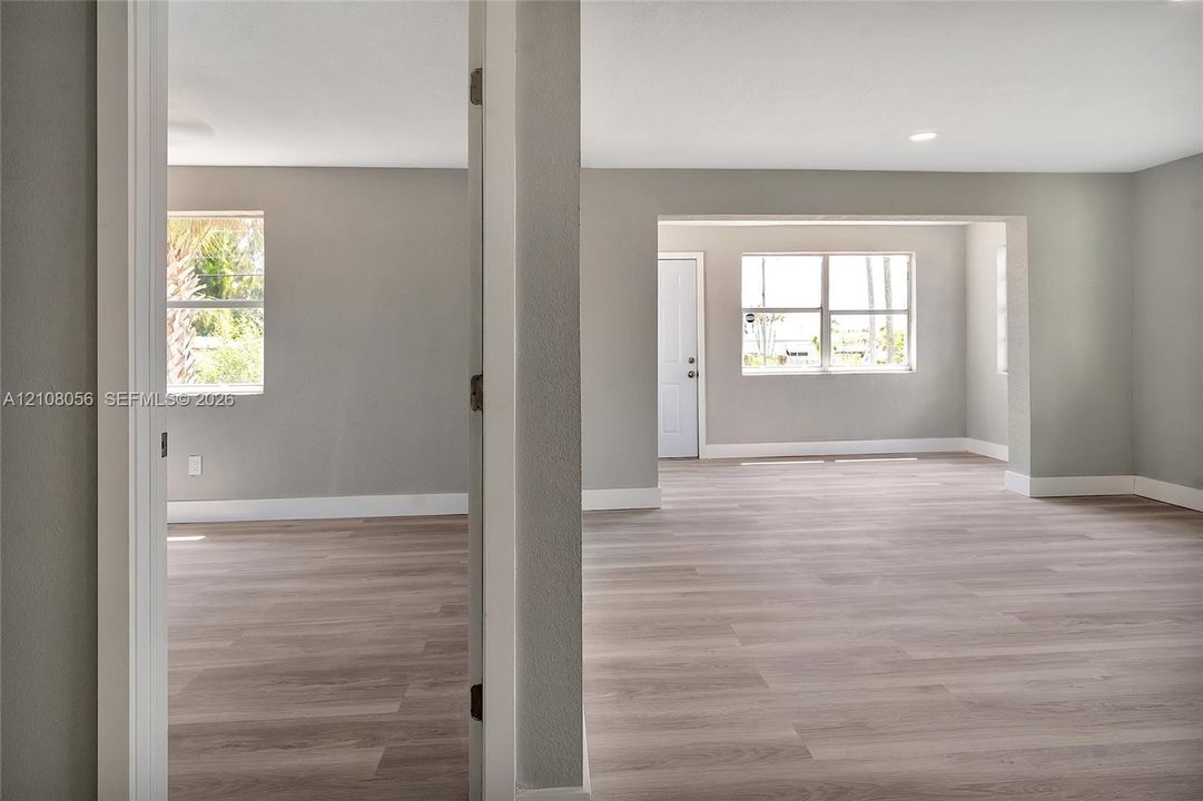 Neutral gray interior walls, wood-finish flooring, multi-pane windows, and recessed lighting
