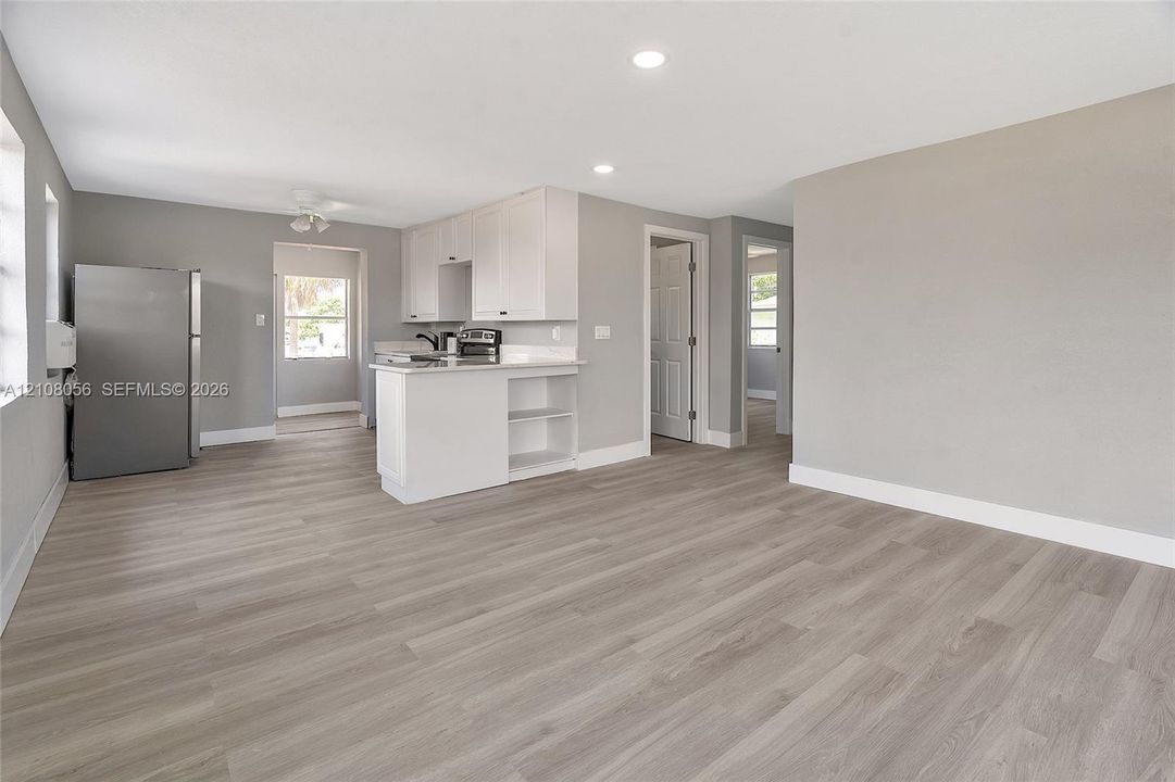 Kitchen featuring white cabinetry, wood-finish flooring, recessed lighting, and a peninsula counter