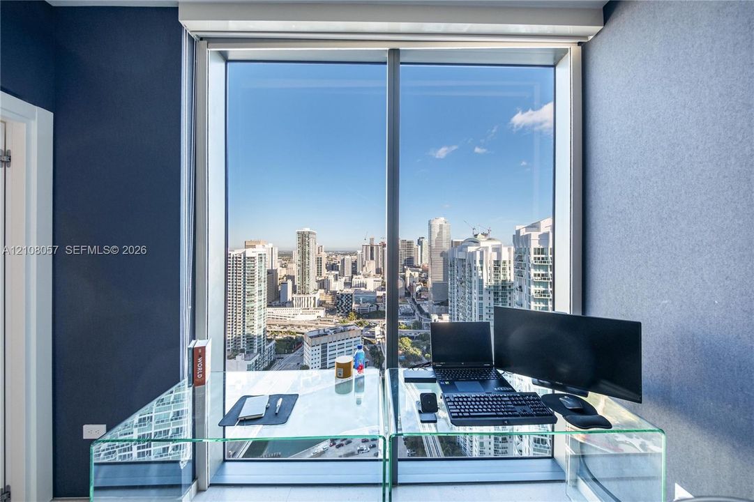 Floor-to-ceiling windows featuring expansive urban cityscapes and metallic framing