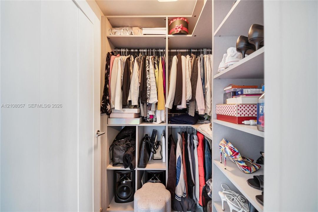 Walk-in closet featuring floor-to-ceiling custom built-in shelving, integrated hanging rods, and adjustable cubby storage