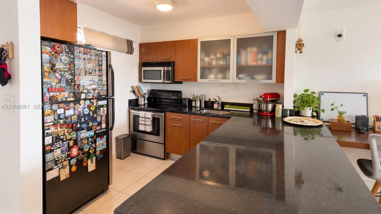 Kitchen featuring wood-finish cabinetry, solid surface countertops, a breakfast bar, and stainless steel appliances