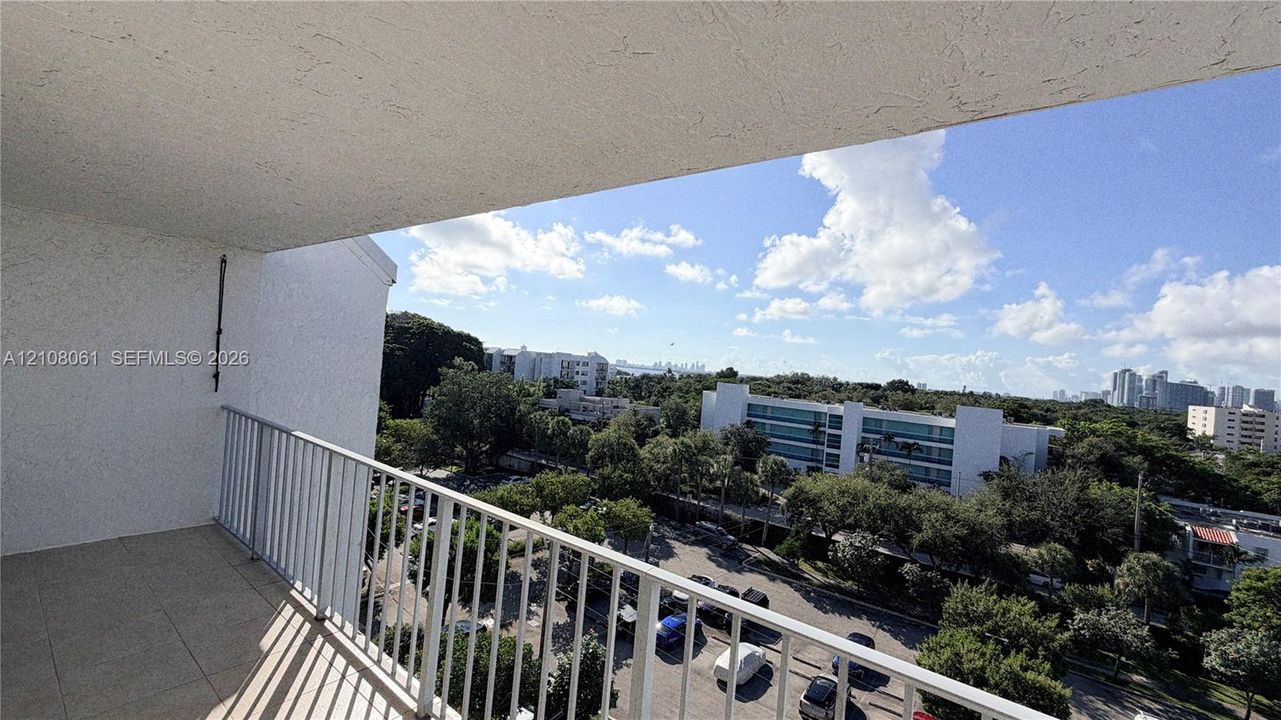 Covered balcony with a white metal railing and tiled flooring