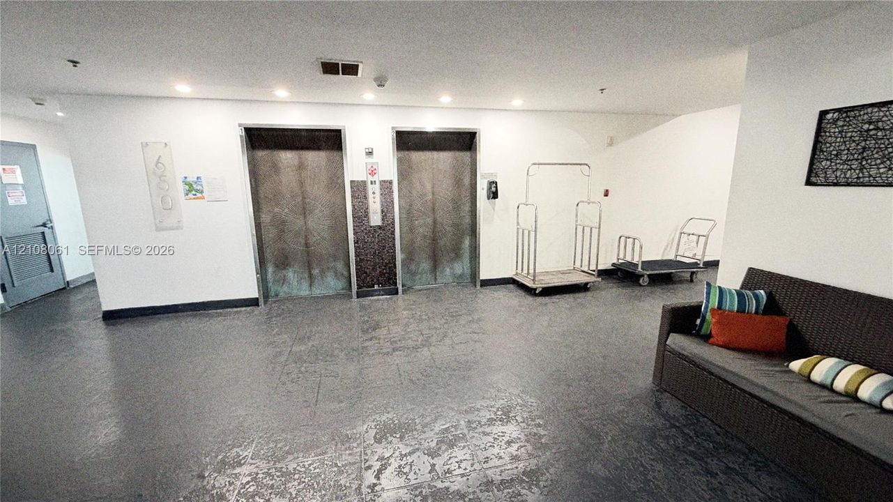 Lobby entrance featuring dual elevators with metallic finish, recessed ceiling lighting, and hard-surface flooring