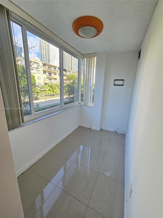 Enclosed space featuring oversized windows, light-tone tile flooring, and a flush-mount dome light fixture