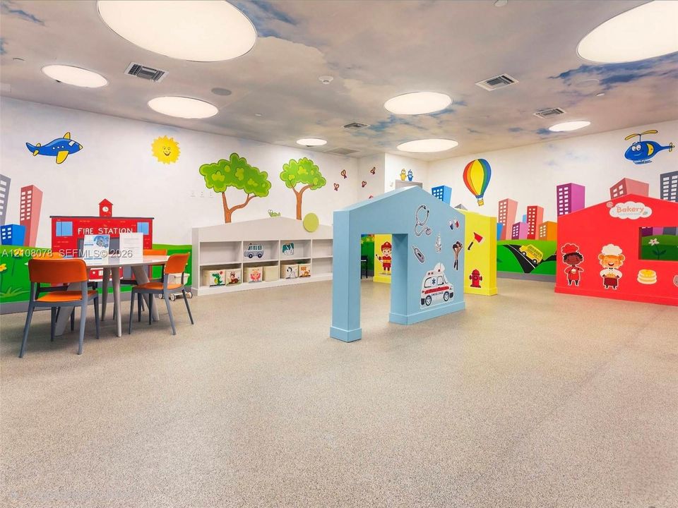 Spacious interior featuring a sky-themed ceiling mural, integrated flush-mount lighting, resilient seamless flooring, custom built-in wall shelving, and decorative structural partition elements