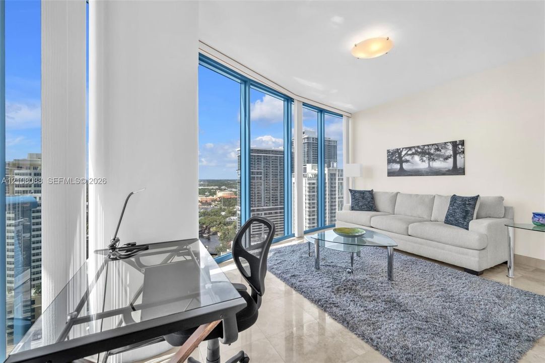 Set up as a den or media room. Queen size pull out sofa. Floor-to-ceiling windows, polished stone flooring, and a flush-mount ceiling light fixture
