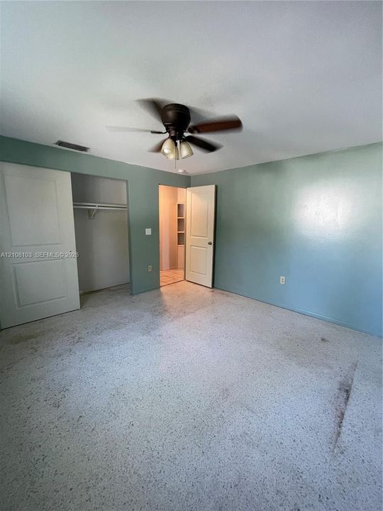 Room featuring terrazzo flooring, ceiling fan with integrated lighting, and dual-panel interior doors