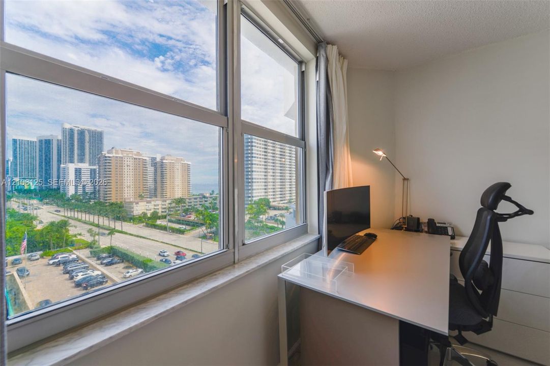 Floor-to-ceiling windows featuring urban scenery and a stone window sill