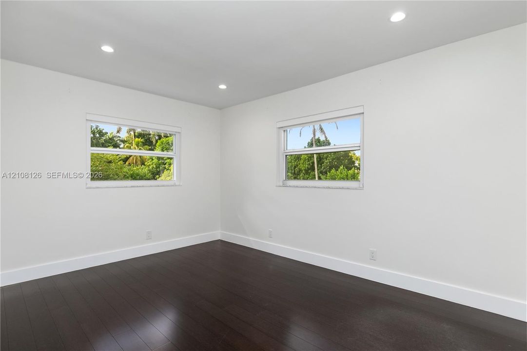 Neutral-toned room with wood-finish flooring, recessed lighting, and double-pane windows