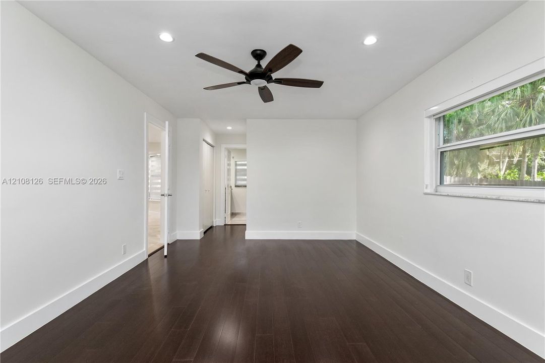 Interior space featuring dark wood-finish flooring, neutral wall paint, recessed lighting, and a ceiling fan