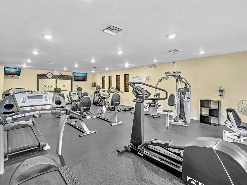 Fitness facility featuring rubberized flooring, recessed lighting, and built-in shelving