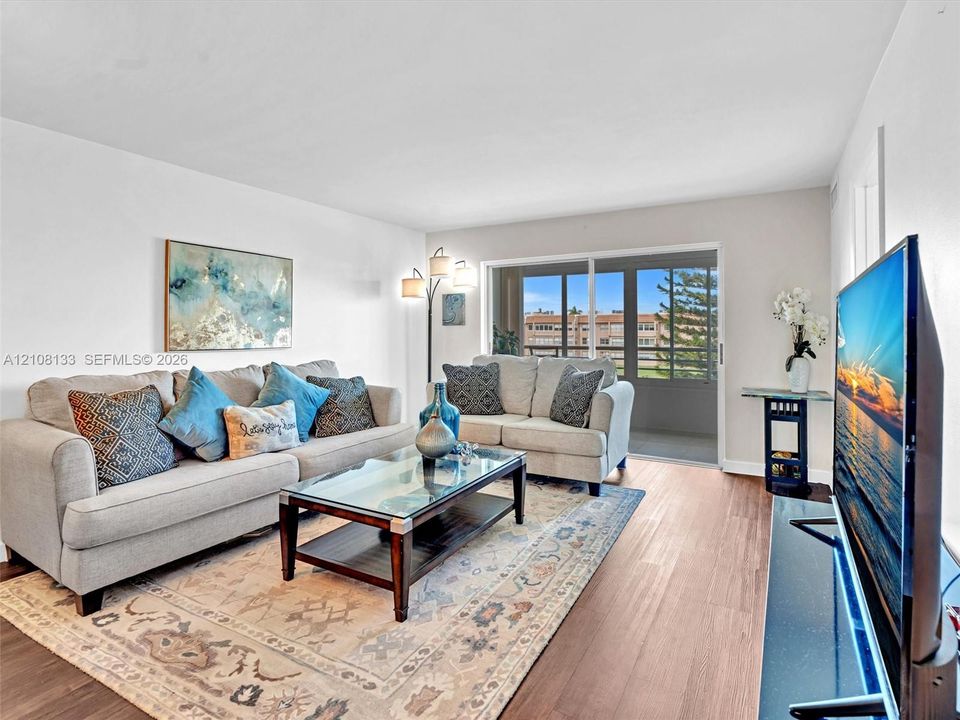 Living area featuring wood-finish flooring and sliding glass doors with access to an exterior balcony