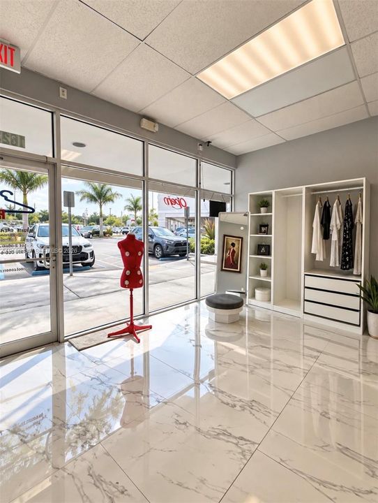 Floor-to-ceiling glass storefront, high-gloss stone-finish tile flooring, recessed drop-ceiling lighting, and built-in floor-to-ceiling cabinetry with integrated hanging rods and drawers