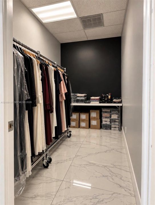 Large-format tile flooring, high-contrast black accent wall, and inset ceiling lighting