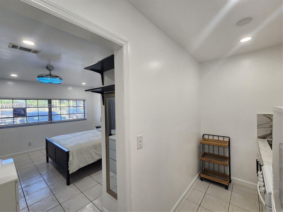 Interior space featuring neutral wall tones, large-format tile flooring, recessed ceiling lighting, and built-in shelving