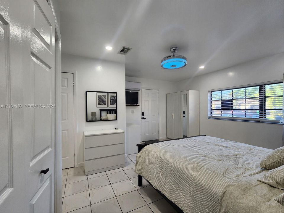 Interior space featuring ceramic tile flooring, recessed ceiling lighting, a contemporary drum-style ceiling fan with integrated lighting, and horizontal window blinds