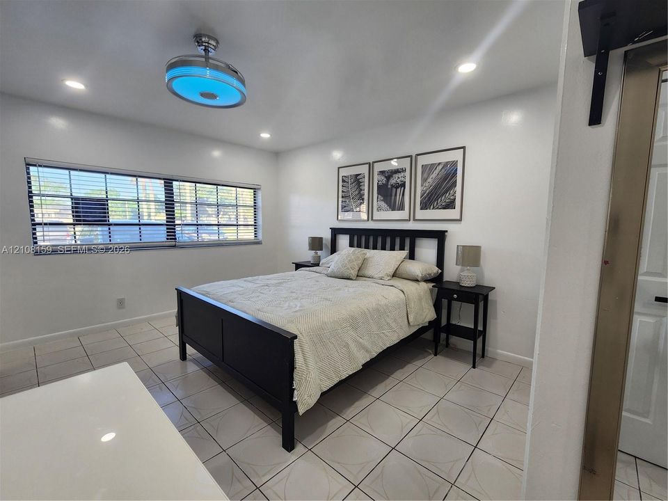 Ceramic tile flooring, recessed lighting, and a contemporary ceiling fan with integrated lighting