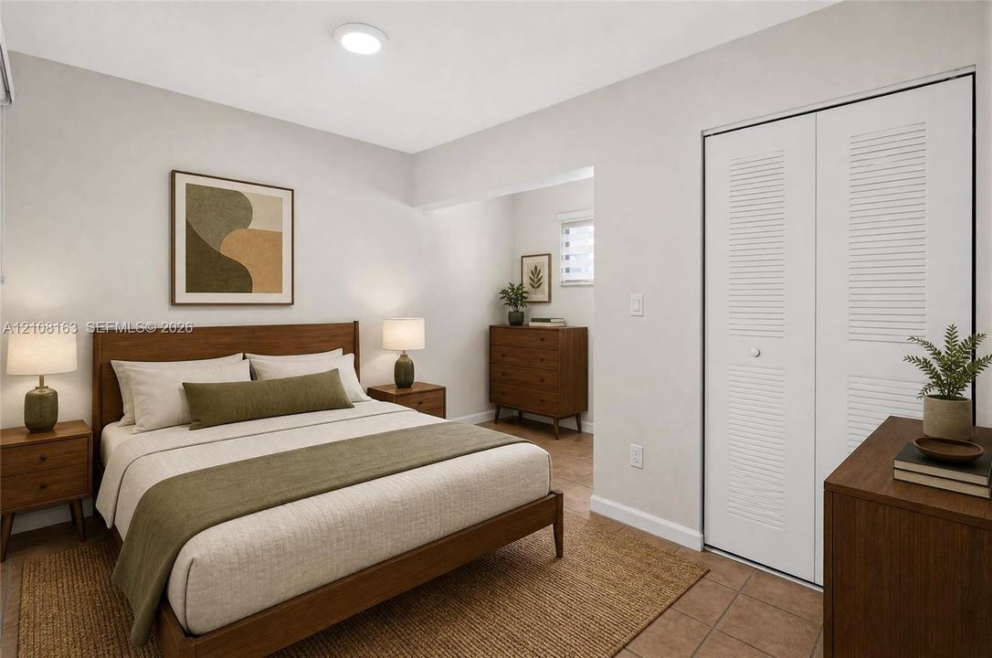 Neutral-toned walls, tile flooring, and closet featuring white dual-panel louvered doors