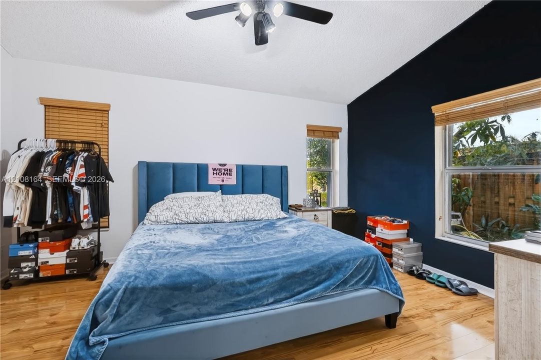 Vaulted ceilings, wood-finish flooring, and natural light via multiple windows with installed wood blinds