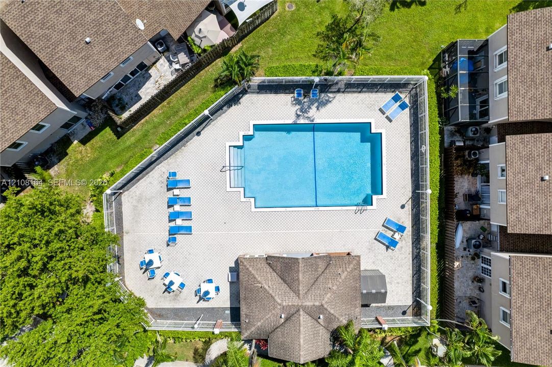 Outdoor swimming pool with integrated stair entry, paver-surfaced decking, and perimeter fencing