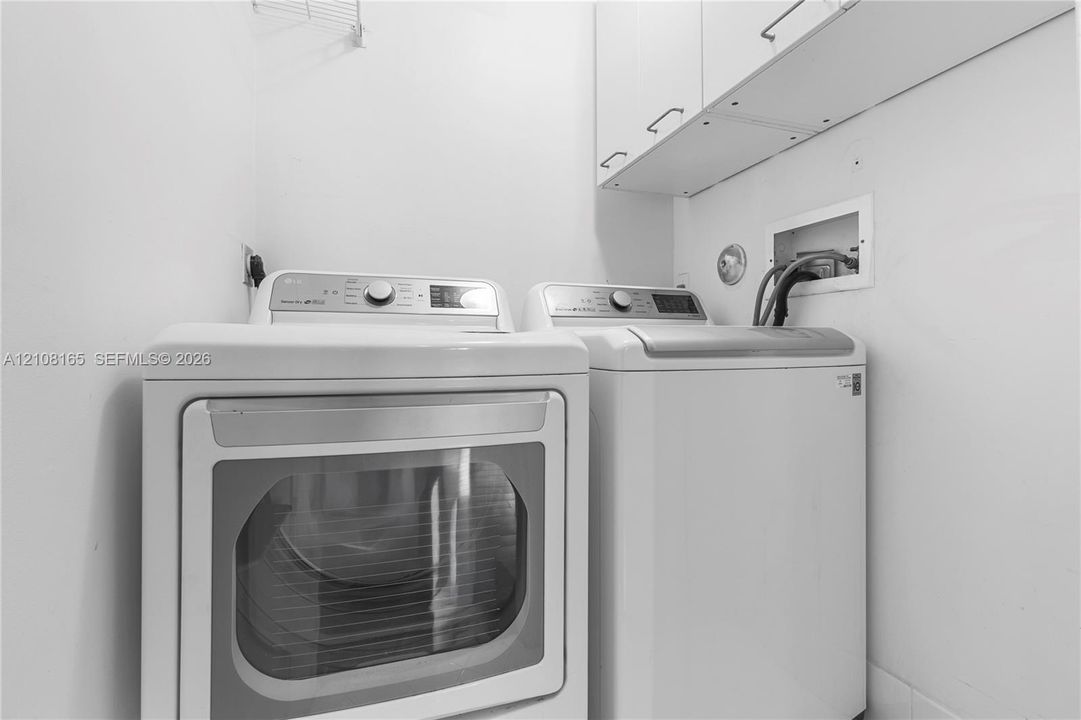 Laundry area featuring white built-in upper cabinetry and integrated machine hookups
