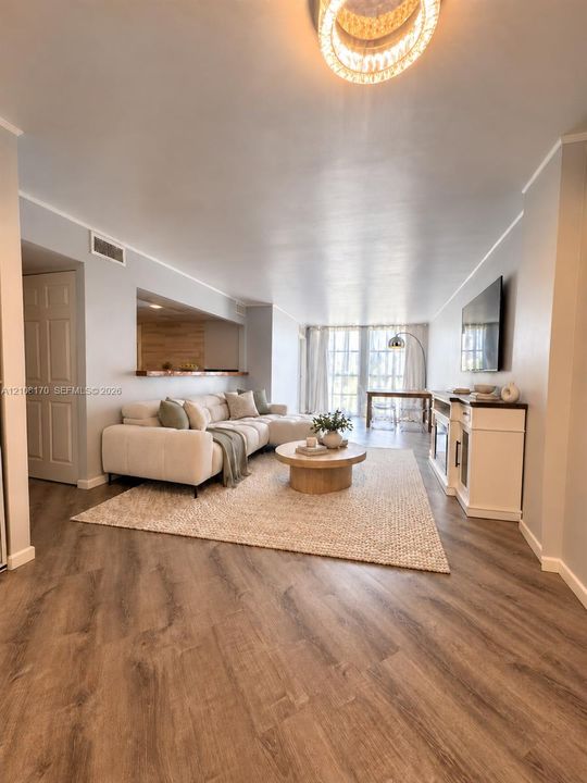 Living area featuring wood-finish flooring, bar, floor-to-ceiling windows and a circular drum chandelier